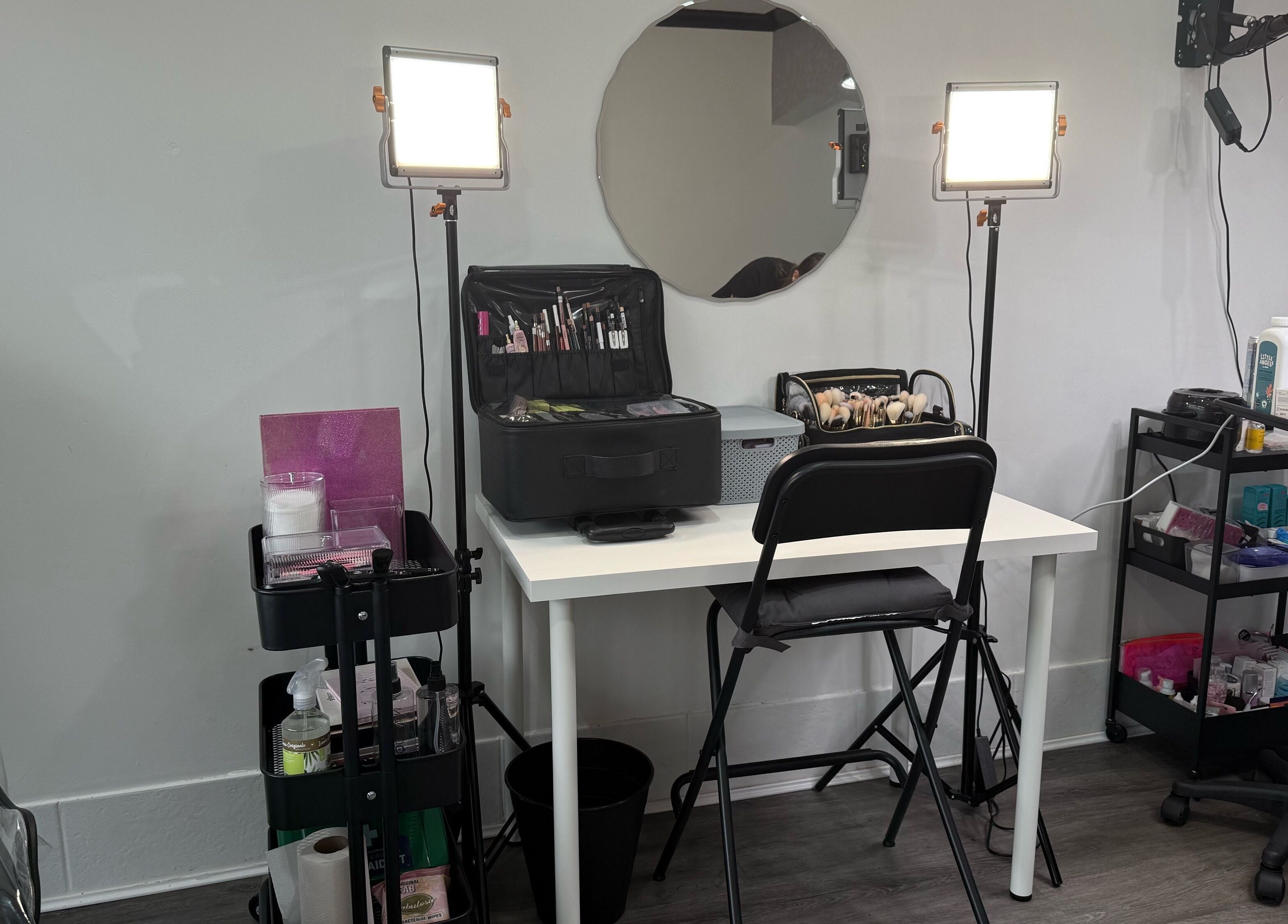 Makeup station at EleanorLarkinMUArtistry in Hindley, England, GB, featuring lights, tools, and mirror.