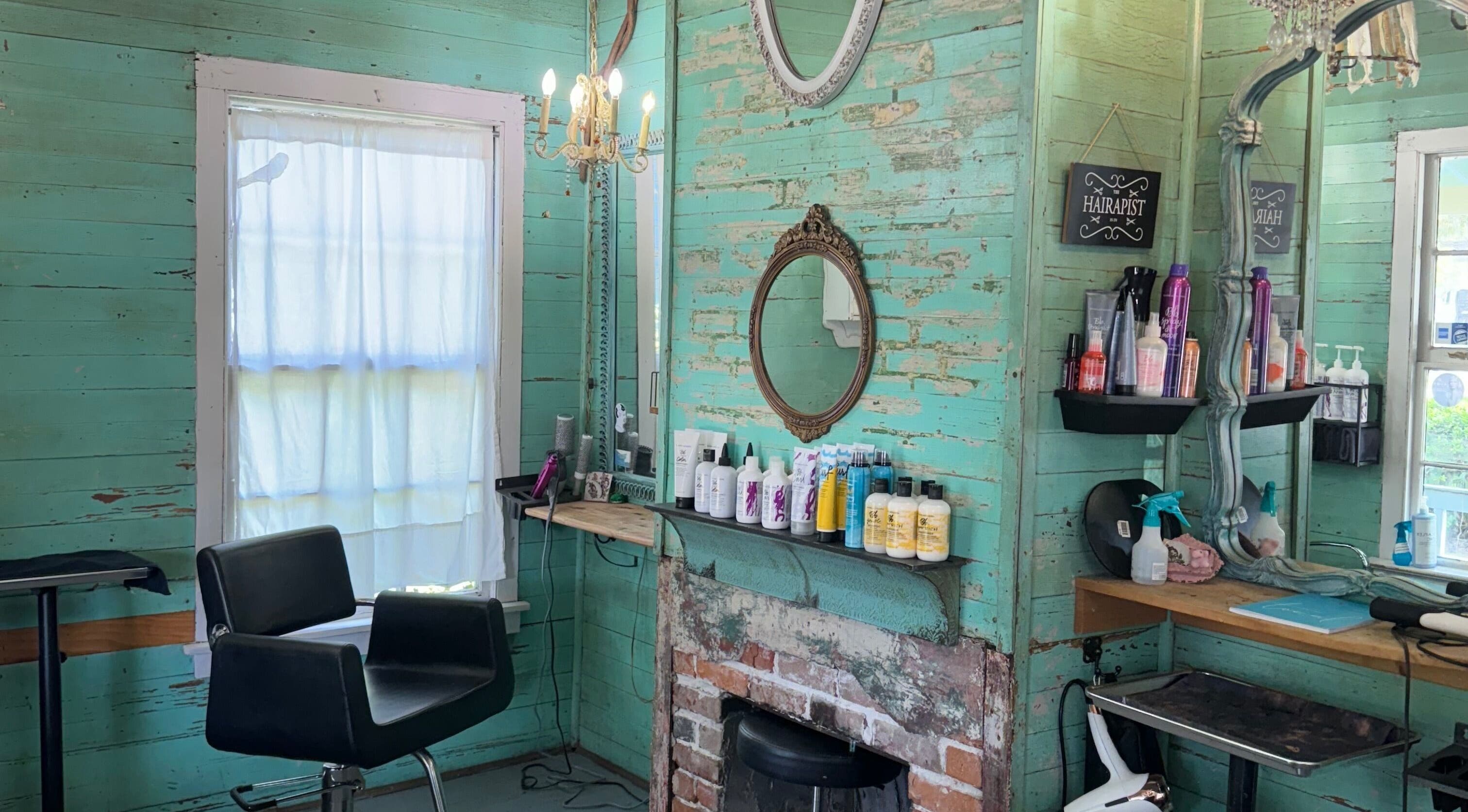 Charming vintage interior of The Bearded Lady Salon in Fernandina Beach, Florida, featuring rustic decor and styling chair.