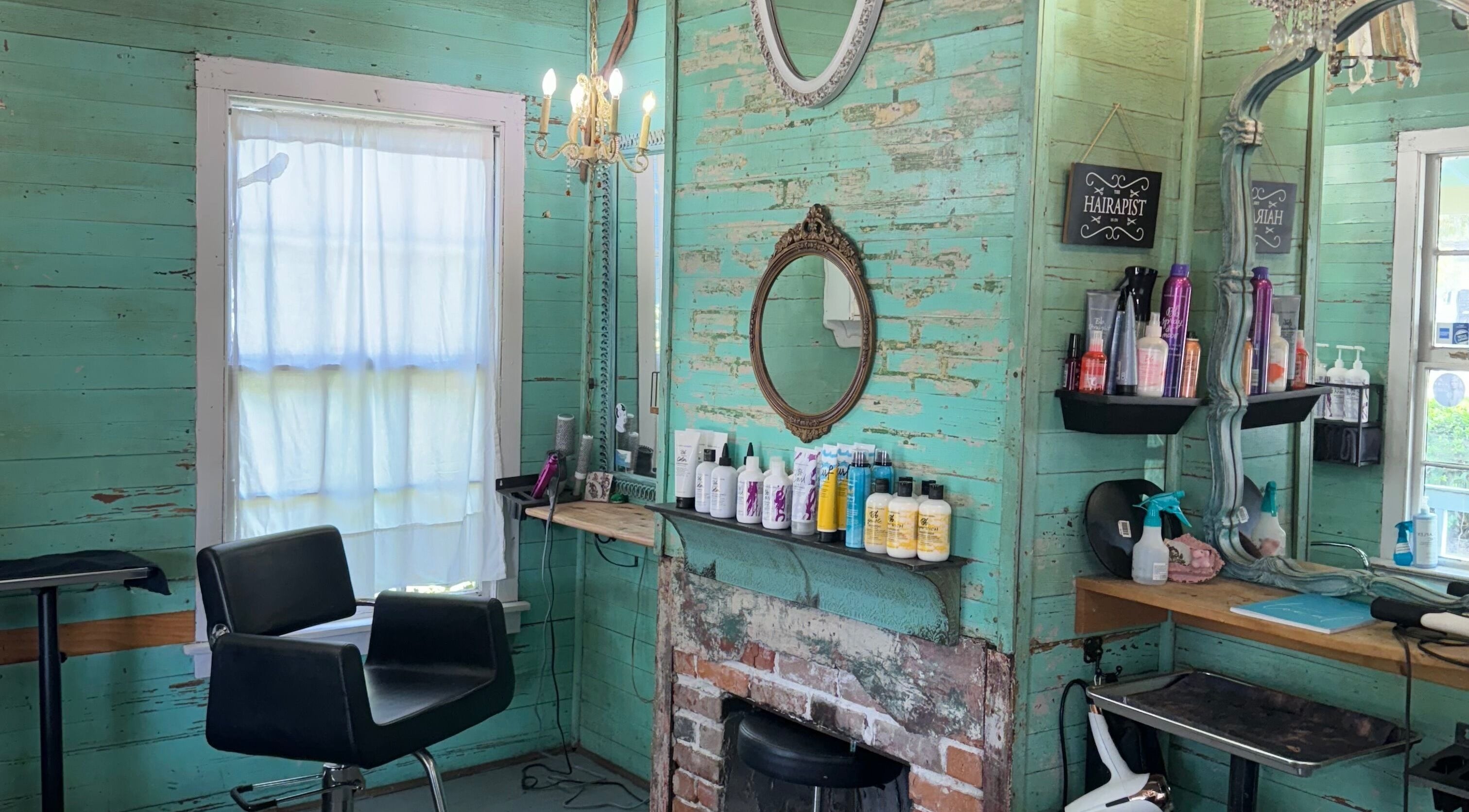 Charming vintage interior of The Bearded Lady Salon in Fernandina Beach, Florida, featuring rustic decor and styling chair.