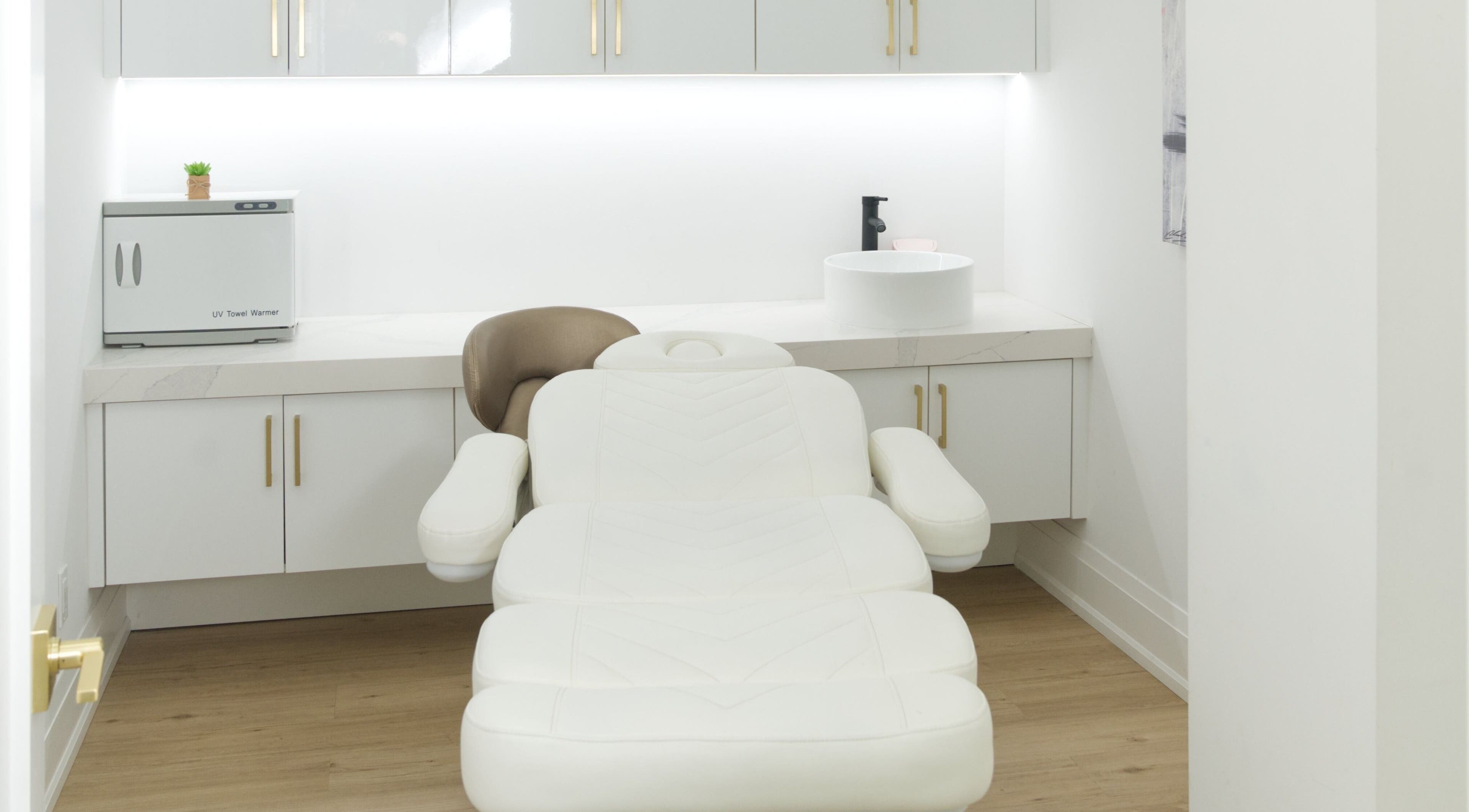 Sleek treatment room at Skin Cave Beauty, Mississauga, Ontario, CA featuring a plush white chair and modern decor.
