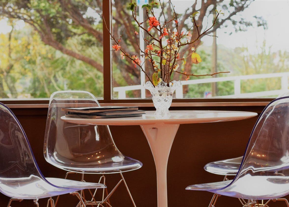 Chic seating area at David's Hairstylists, Wellington, NZ. Modern chairs around a round table with floral decor.