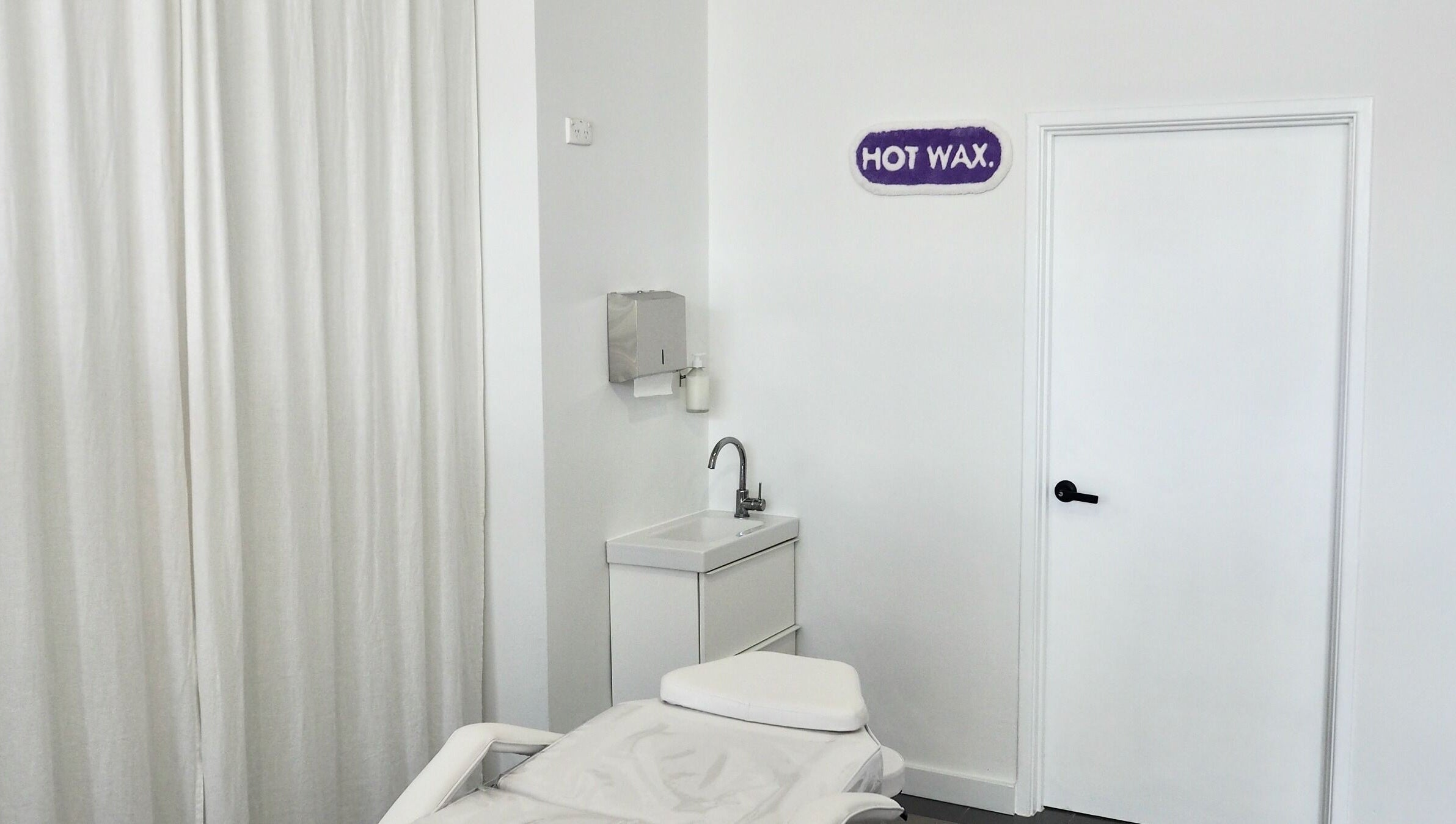 Relaxing treatment room at Hot Wax in Wembley, Western Australia, AU with a spa bed and sink.