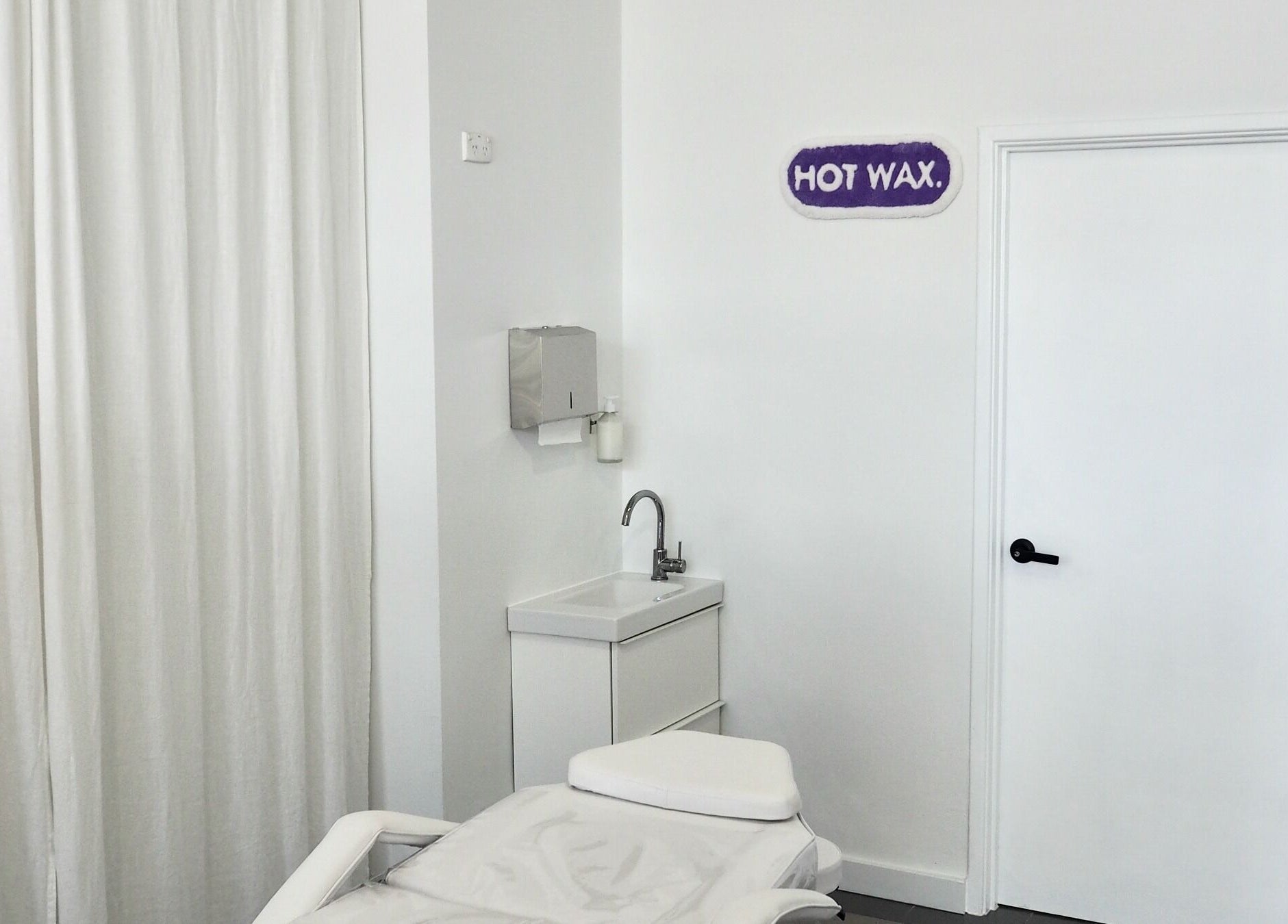 Relaxing treatment room at Hot Wax in Wembley, Western Australia, AU with a spa bed and sink.