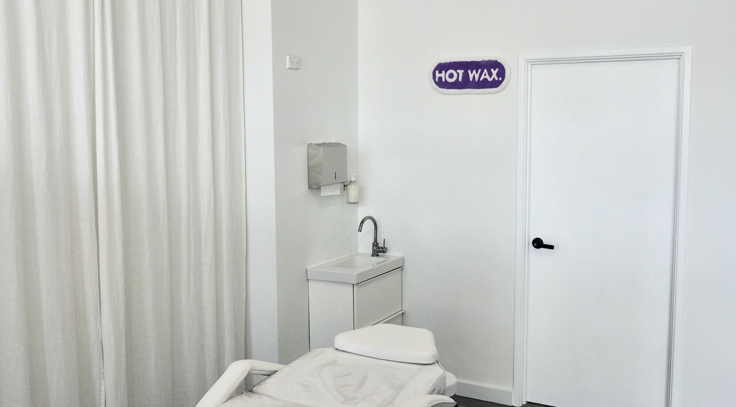 Relaxing treatment room at Hot Wax in Wembley, Western Australia, AU with a spa bed and sink.
