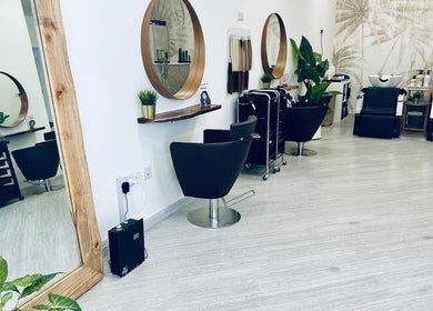 Modern interior of Mane Street Ladies Salon at إمارة رأس الخيمة, featuring sleek styling chairs and mirrors.
