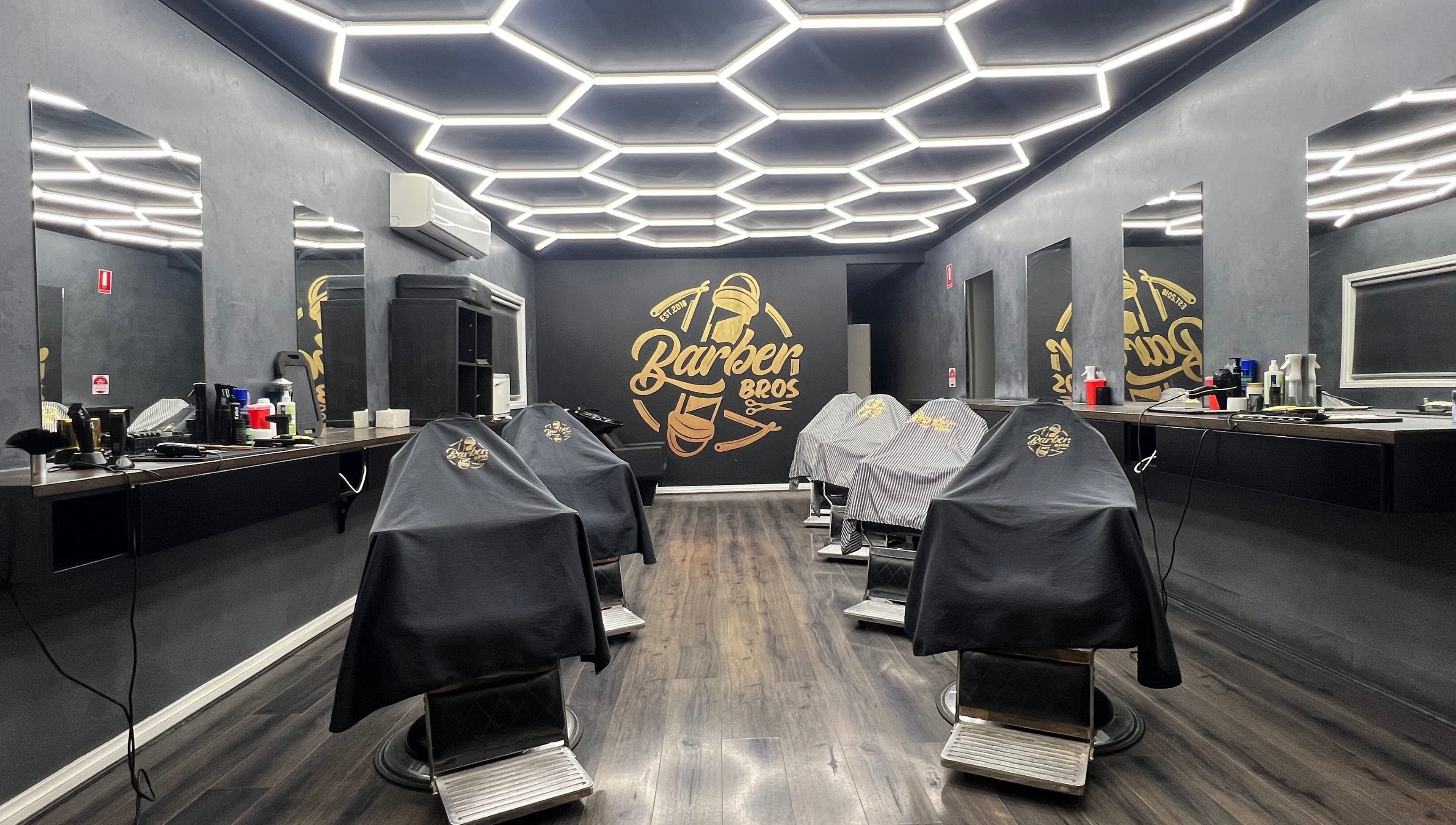 Modern interior of Barber Bros in Melbourne, Victoria, AU with stylish lighting and barber chairs.