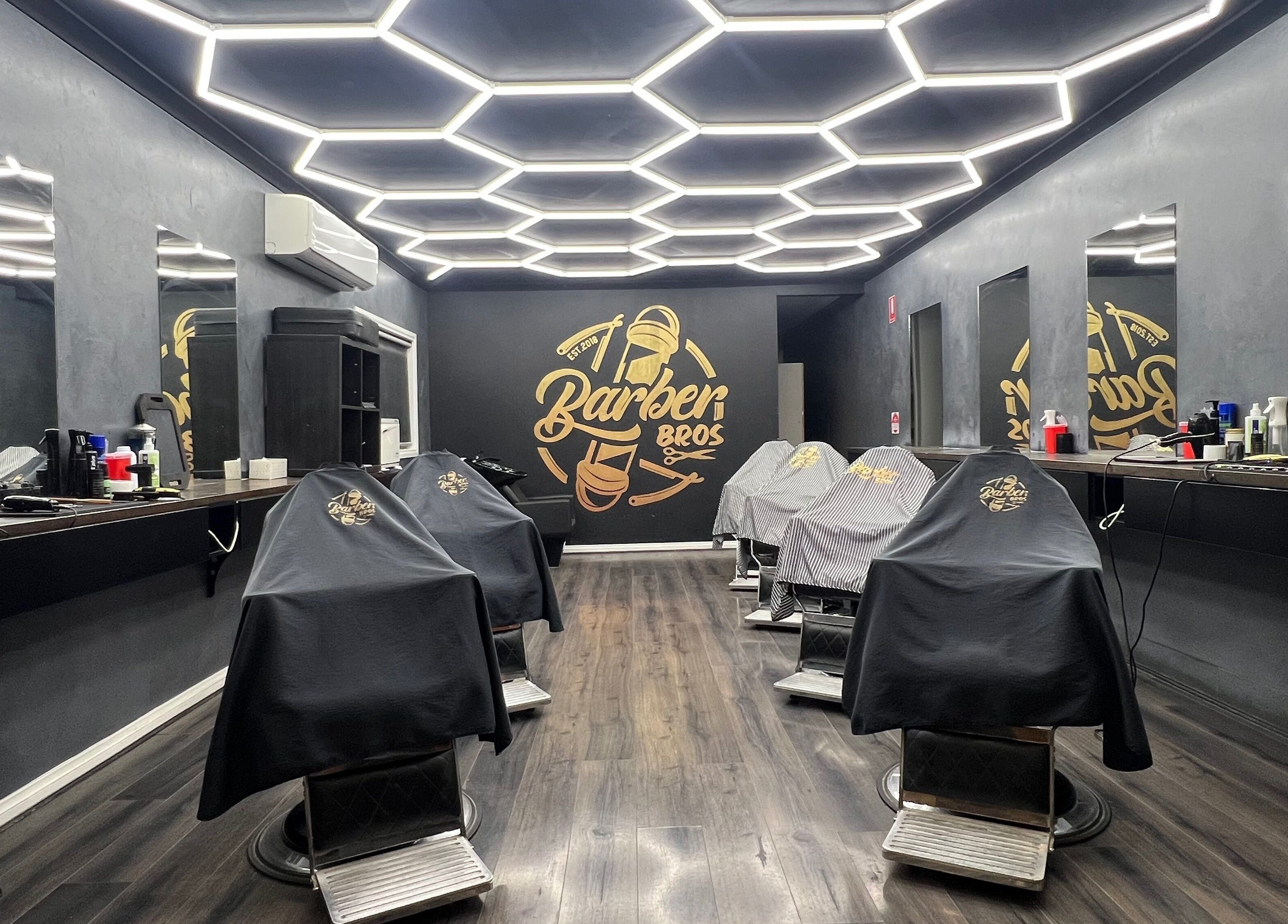 Modern interior of Barber Bros in Melbourne, Victoria, AU with stylish lighting and barber chairs.