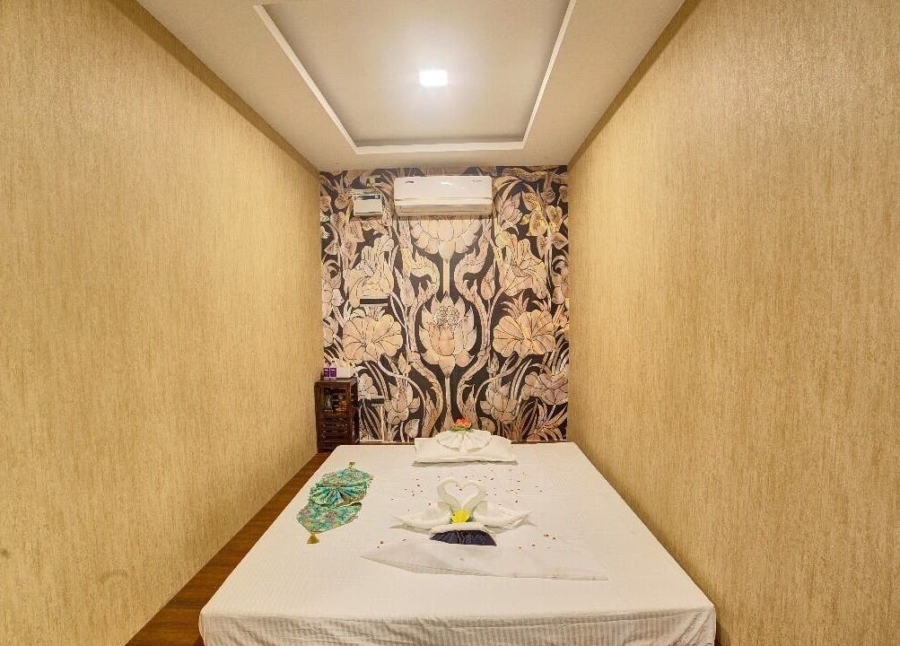 Peaceful spa room with massage bed at Hasta Spa Tada, Tada, Andhra Pradesh, IN. Elegant floral wall design.