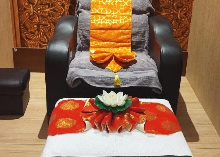 Elegant relaxation chair at Hasta Spa Tada, Tada, Andhra Pradesh, IN, adorned with lotus and orange accents.