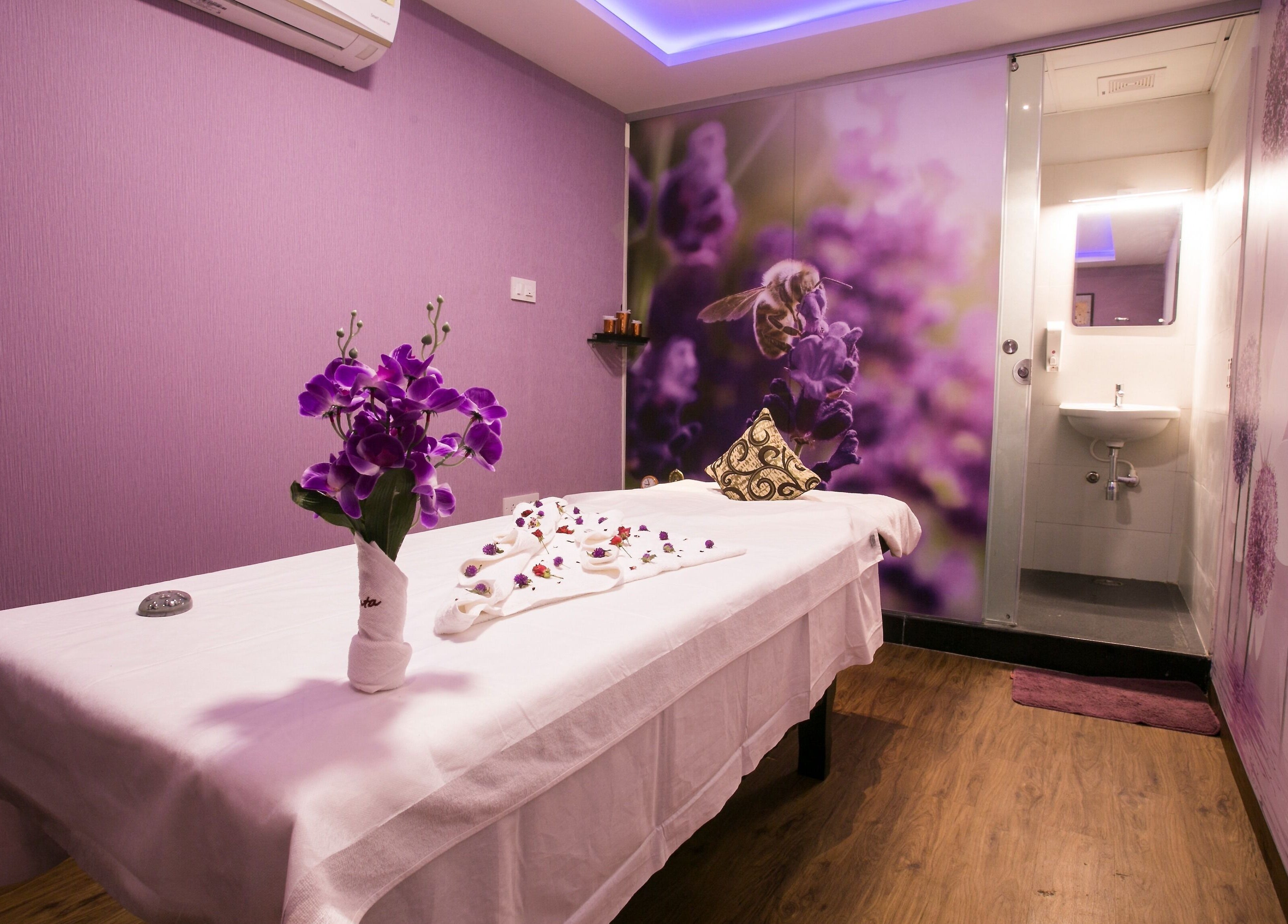 Relaxing massage room at Hasta Spa Virugambakkam, Chennai, Tamil Nadu, IN with lavender accents and floral decor.