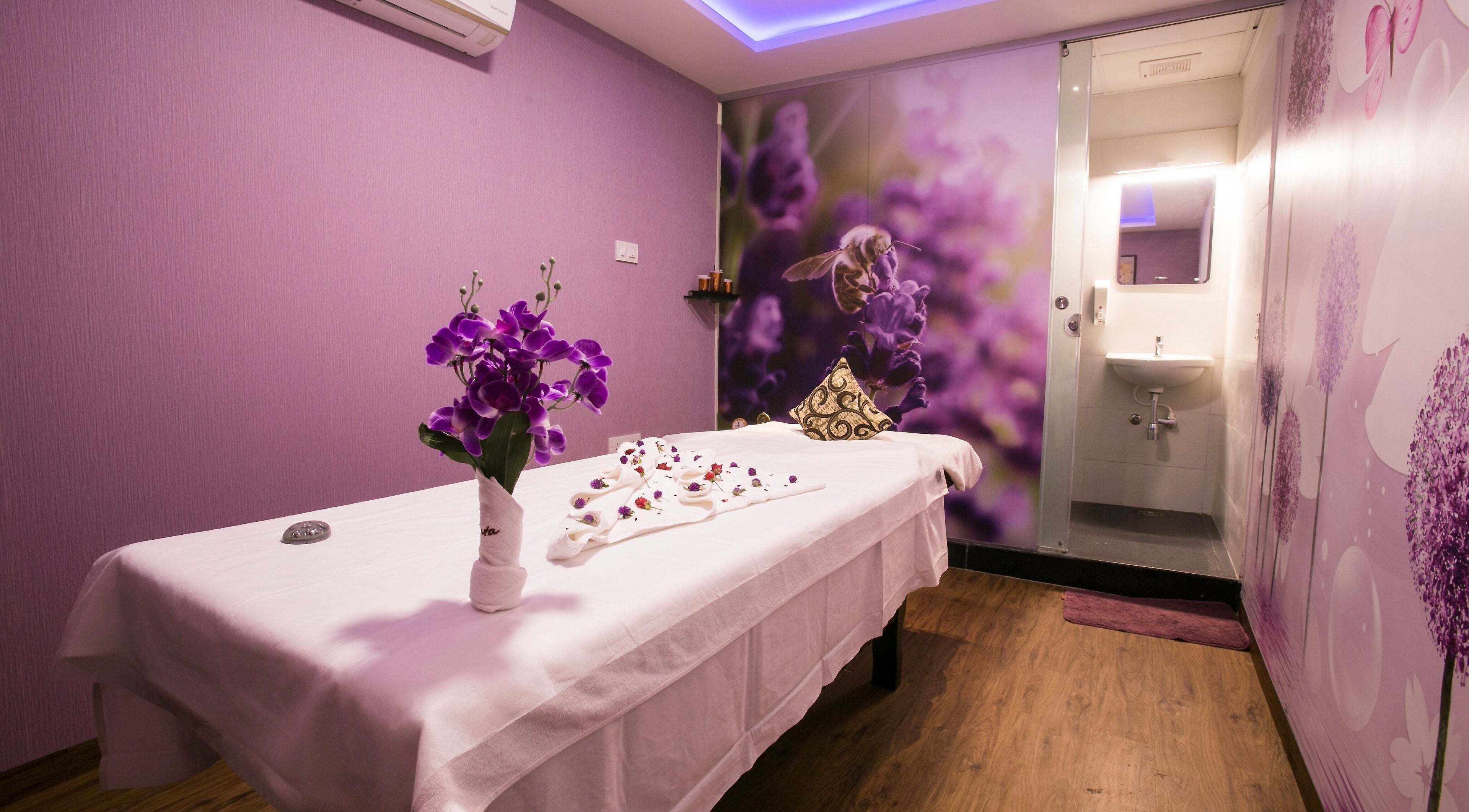 Relaxing massage room at Hasta Spa Virugambakkam, Chennai, Tamil Nadu, IN with lavender accents and floral decor.