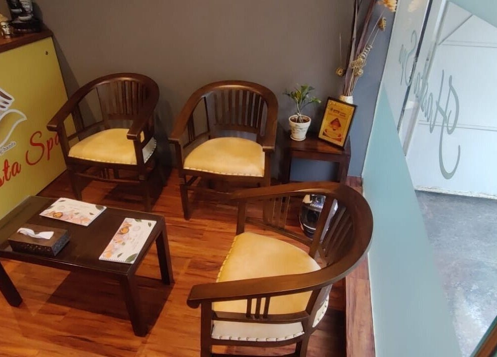 Relaxing waiting area at Hasta Spa Anna Nagar, Chennai, Tamil Nadu, IN featuring wooden chairs and a soothing ambiance.