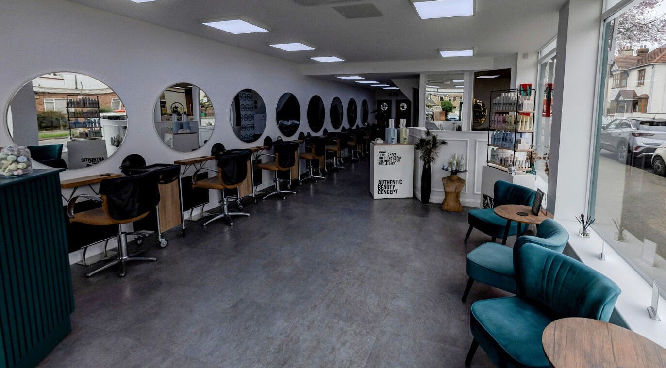 Brush.71 salon in Southend-on-Sea, England, GB with modern seating and round mirrors on a sleek wall.
