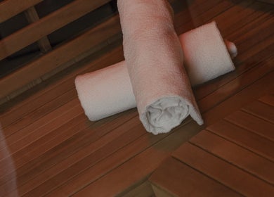 Fresh towels on sauna bench at Mesa Health & Wellness Studio, Freshwater, AU, promoting relaxation and luxury.