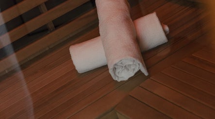 Fresh towels on sauna bench at Mesa Health & Wellness Studio, Freshwater, AU, promoting relaxation and luxury.