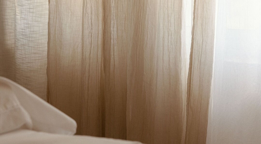 Soothing beige curtains at Mesa Health & Wellness Studio in Freshwater, AU, creating a calm atmosphere.