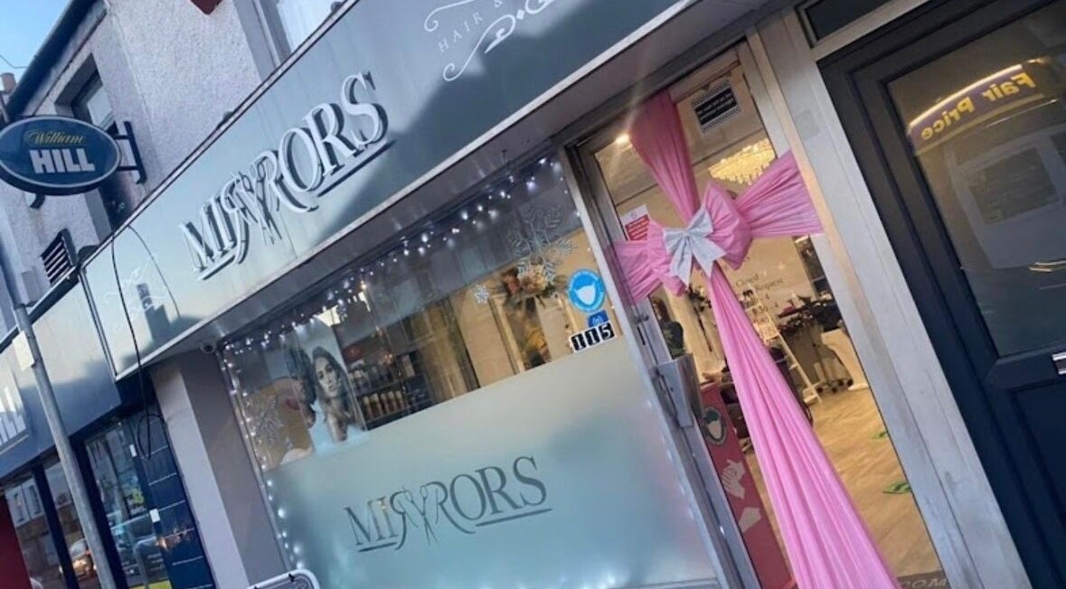 Exterior view of Mirror Hair & Beauty, Newport, Wales, GB with pink ribbon decor and elegant signage.