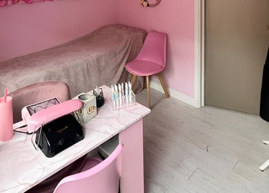 Cozy pink treatment room at Aurora Beauty, Redditch, England, GB, featuring a manicure station and soft decor.