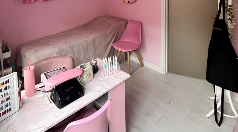 Cozy pink treatment room at Aurora Beauty, Redditch, England, GB, featuring a manicure station and soft decor.