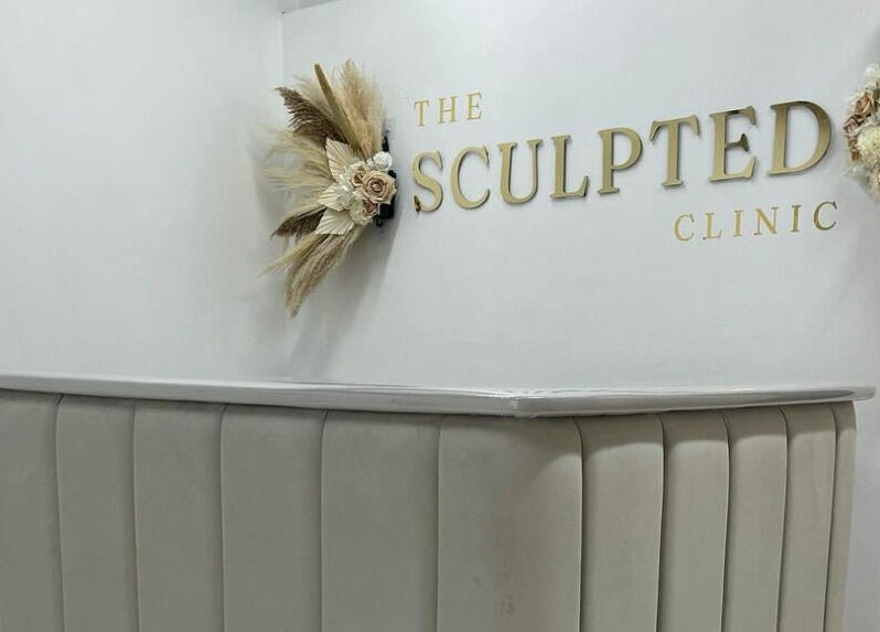 Stylish reception desk at The Sculpted Clinic, Towcester, England, GB with modern decor and logo.