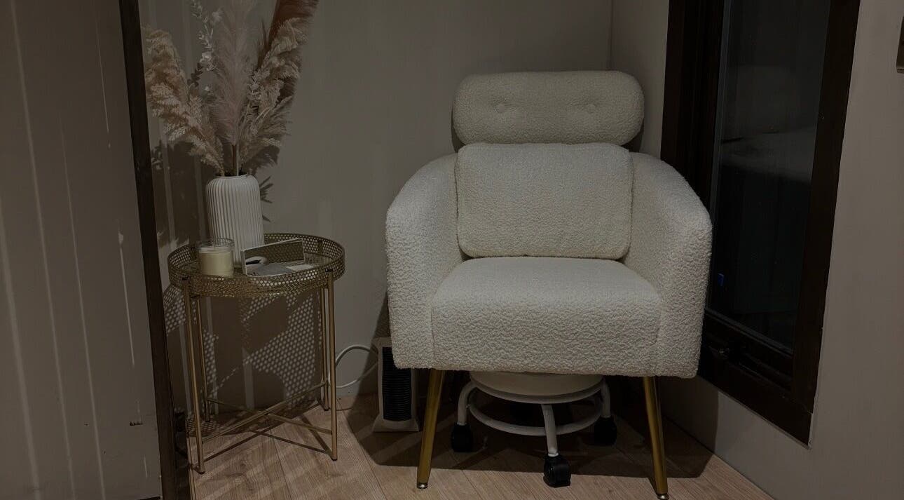 Cozy seating area at By Emily Elizabeth in Ripley, England, GB featuring a plush chair and decorative vase.