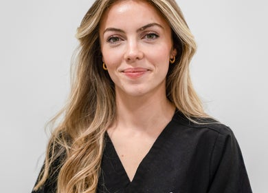 Staff member at Dr Wells Clinic - Medical Aesthetics & Wellness, London, England, GB, smiling in uniform.