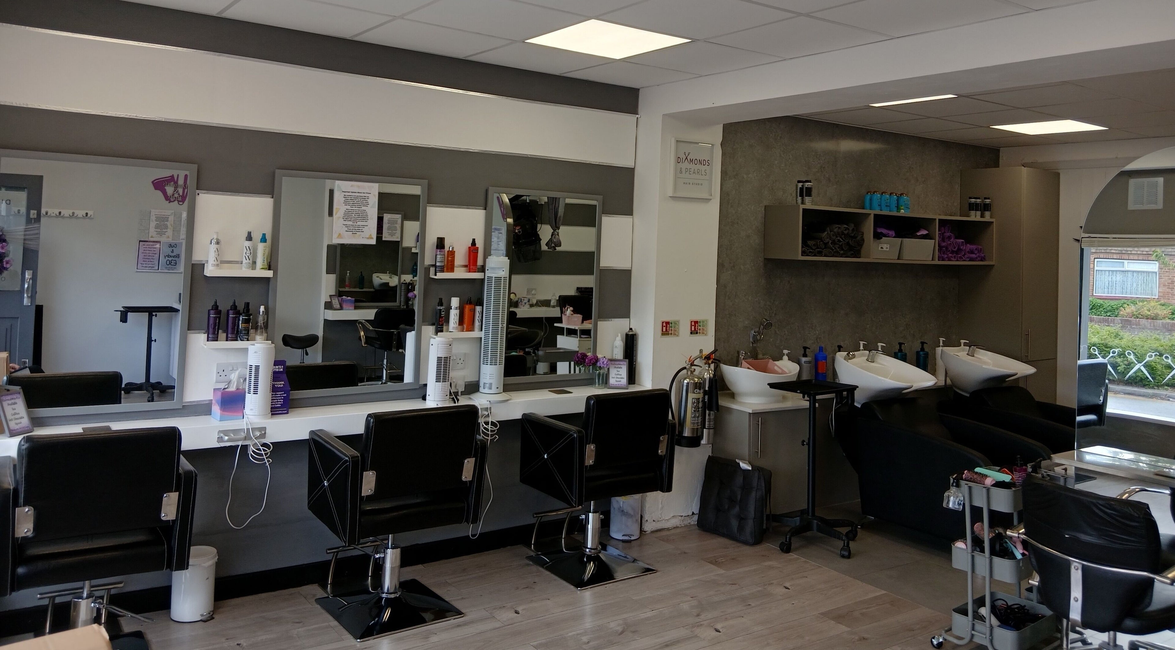 Interior of Diamonds and Pearls Hair Studio in Northfleet, England, GB with styling chairs and hair wash stations.