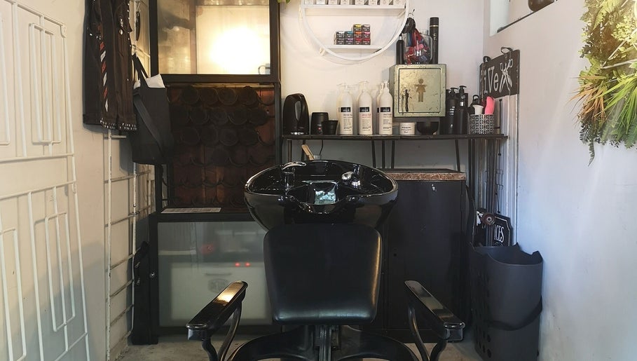 Modern wash station at fiVe Hair Barber in Cape Town, Western Cape, ZA, with sleek black chair and shelves.