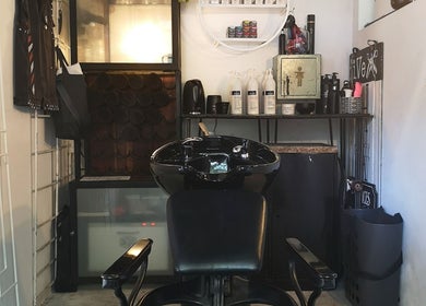 Modern wash station at fiVe Hair Barber in Cape Town, Western Cape, ZA, with sleek black chair and shelves.