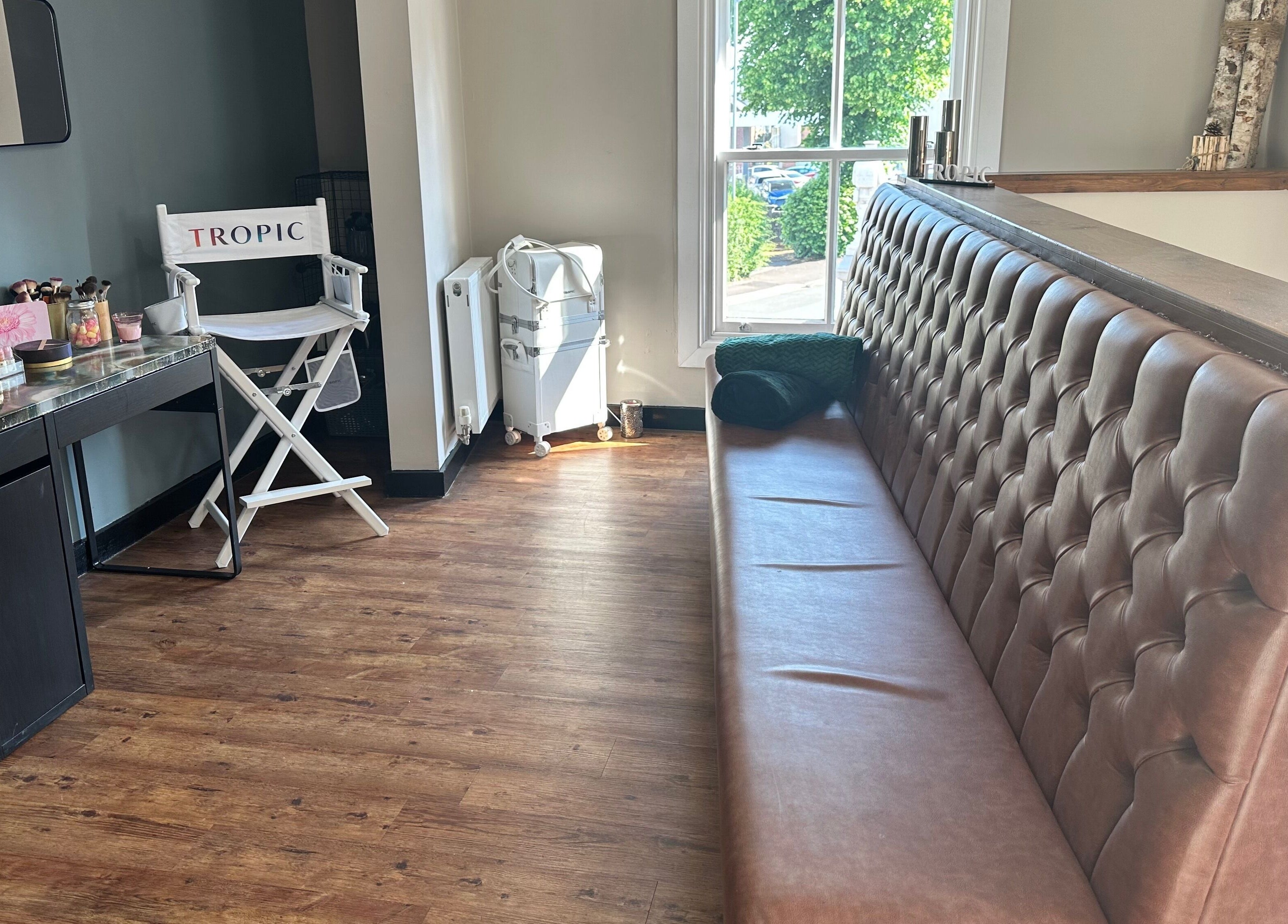 Elegant seating at The Elite Retreat, Biddulph, SOT, England, with makeup station and cozy bench.