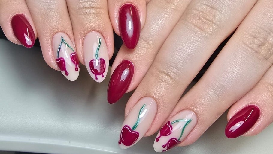 Stylish cherry nail art by Nails by Ashley, Bangor, Northern Ireland, GB, showcasing vibrant red hues.