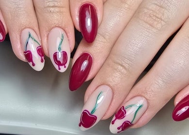 Stylish cherry nail art by Nails by Ashley, Bangor, Northern Ireland, GB, showcasing vibrant red hues.