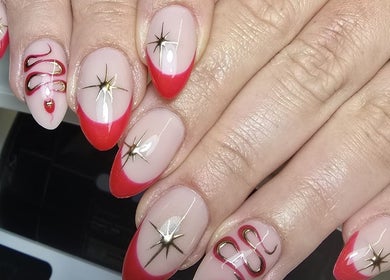 Elegant red-tipped nail art with star designs at Nails by Ashley, Bangor, Northern Ireland, GB.