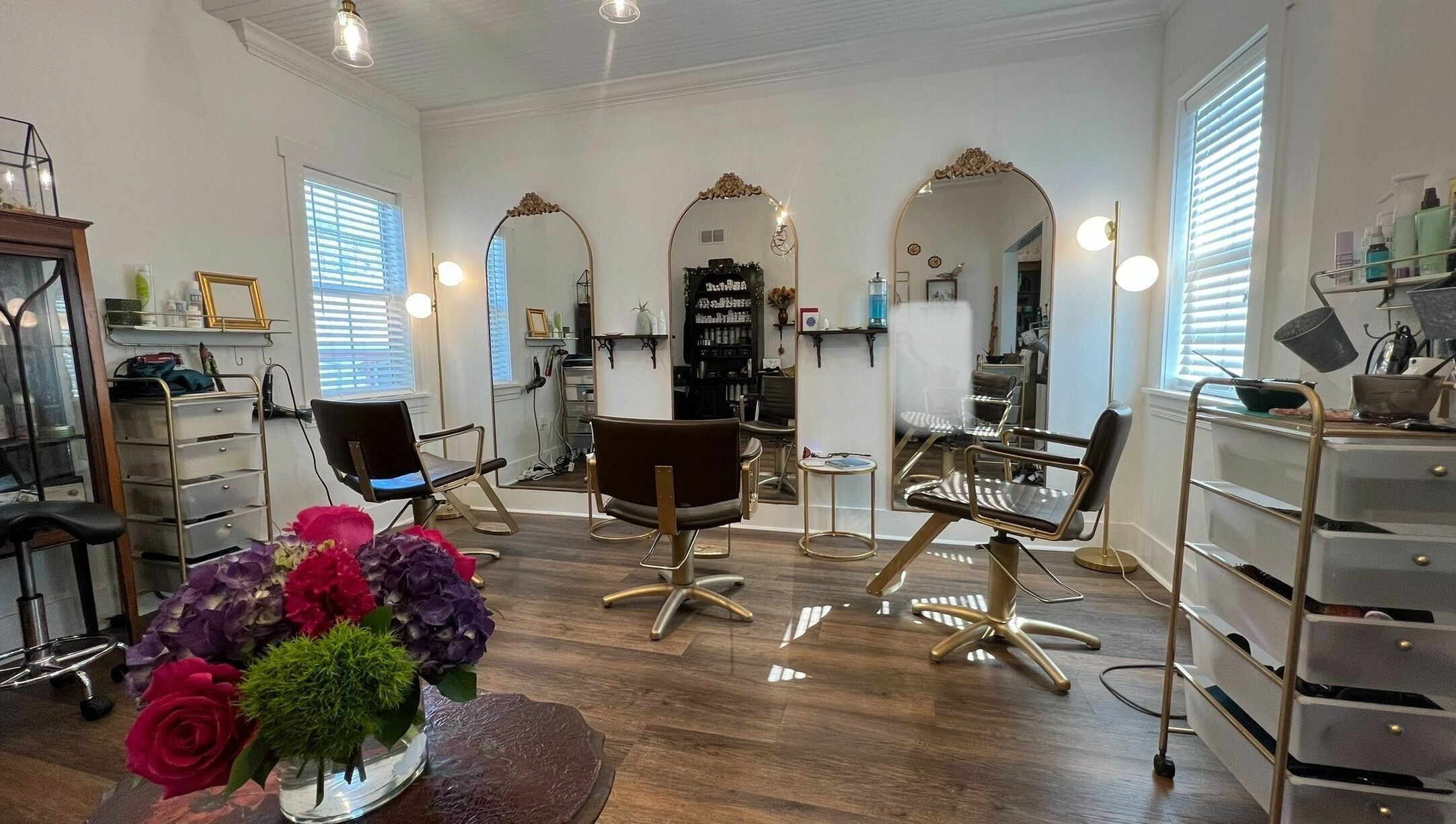 Bright salon interior at All The Things Salon and Wellness, Fort Myers, Florida, US with chic decor and mirrors.