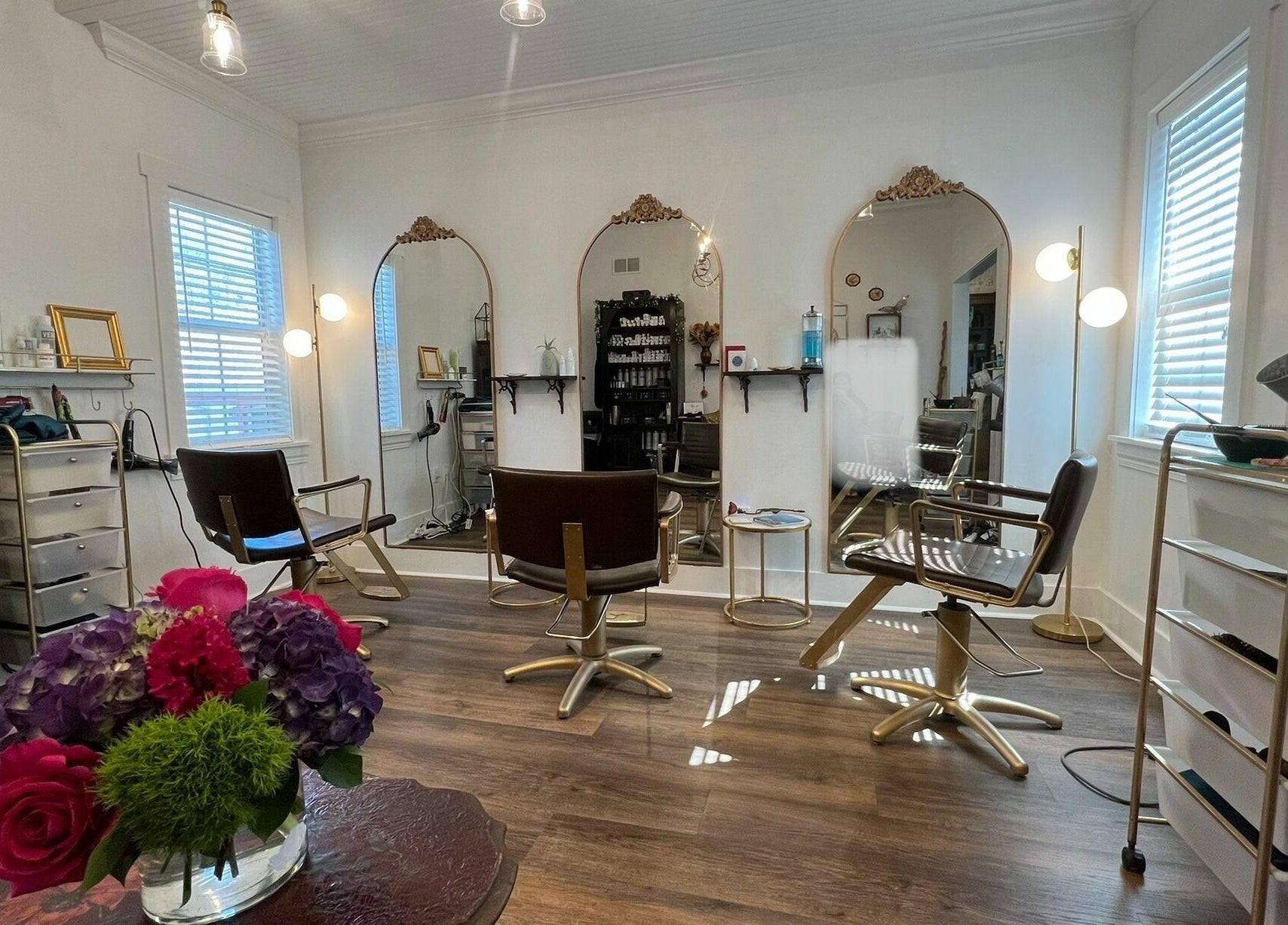 Bright salon interior at All The Things Salon and Wellness, Fort Myers, Florida, US with chic decor and mirrors.
