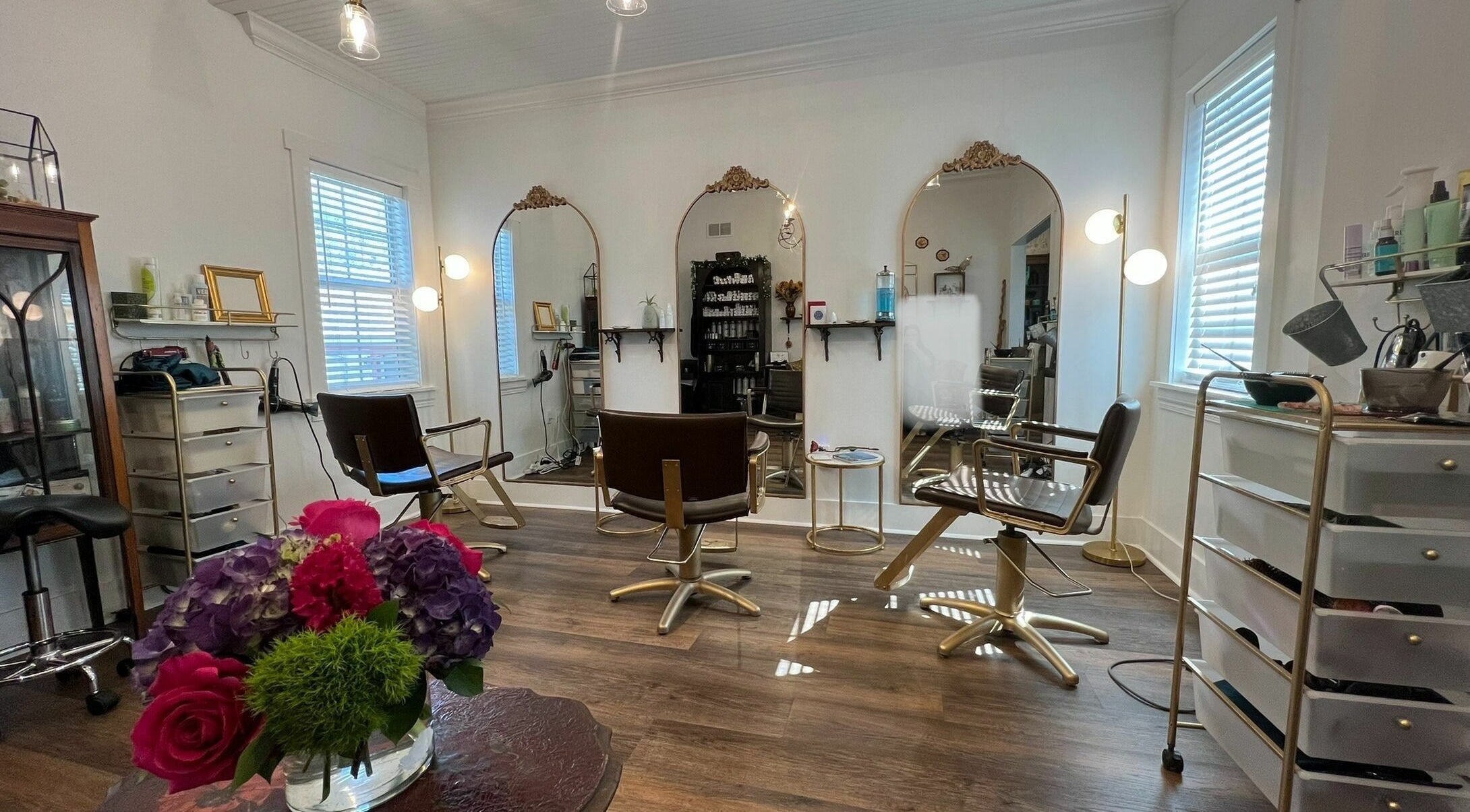Bright salon interior at All The Things Salon and Wellness, Fort Myers, Florida, US with chic decor and mirrors.