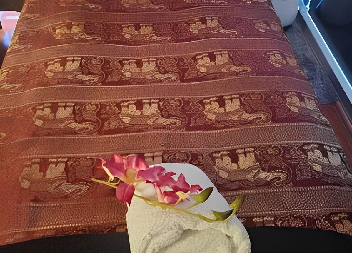 Luxurious massage table at Beyonder Relax and Wellness, Paradise Point, Queensland, AU, with ornate fabric and flowers.