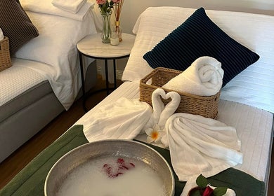 Relaxing massage beds at Youi Thai Massage in New Farm, Queensland, AU with towels and floral decor.