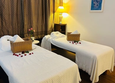 Relaxing twin massage beds at Youi Thai Massage, New Farm, Queensland, AU, decorated with rose petals and baskets.
