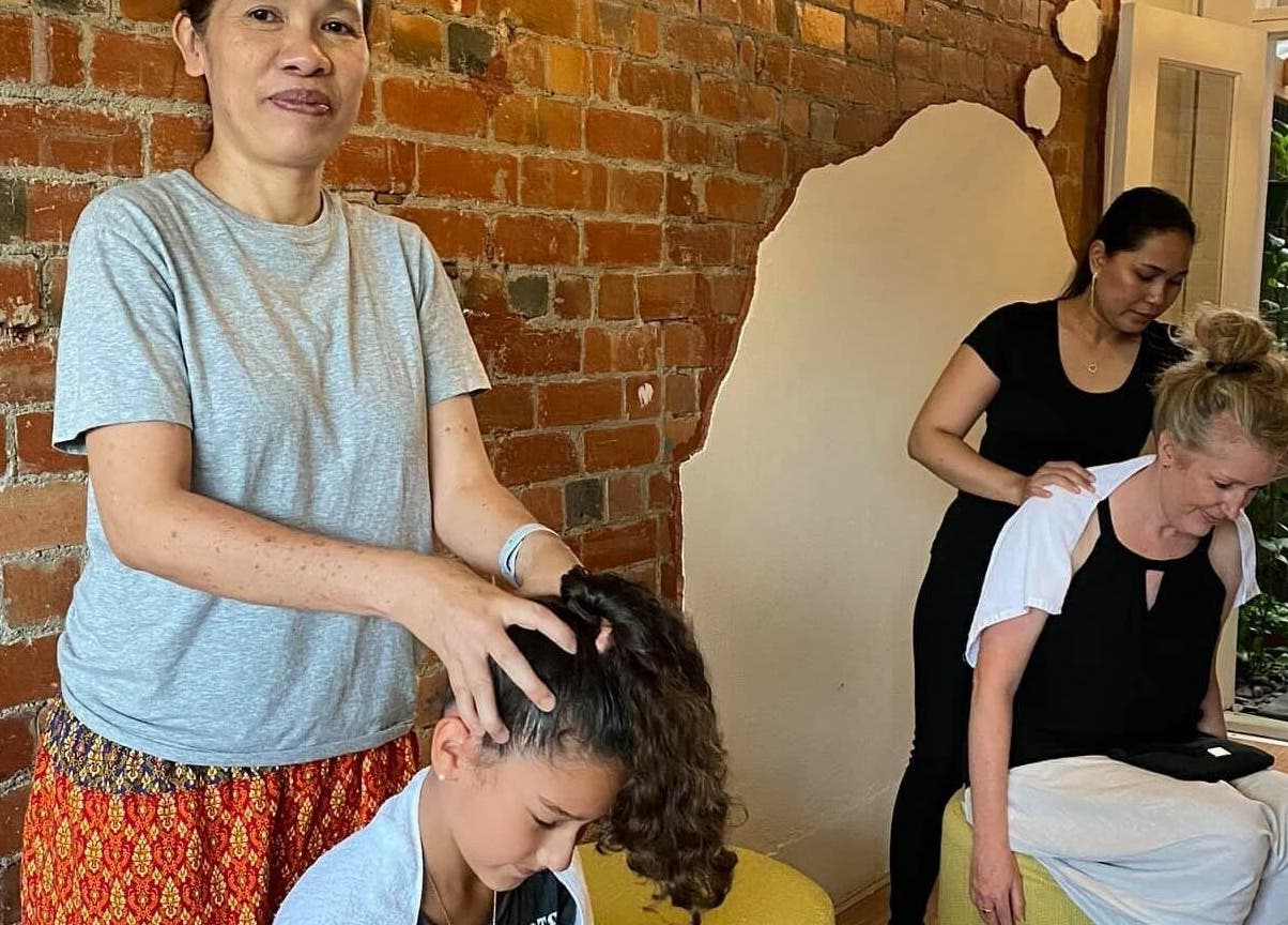 Two individuals enjoying massages at The Massage Studio in Melbourne, Victoria, AU against a rustic brick wall.