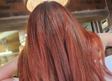 Silky copper hair styled at Mariska J Hairstylist, Pretoria, Gauteng, ZA, gleaming under salon lights.