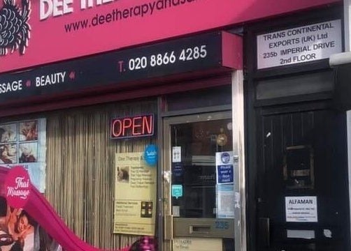 Entrance of Dee Therapy & Salon in Harrow, England, GB, featuring bold pink signage and open neon sign.