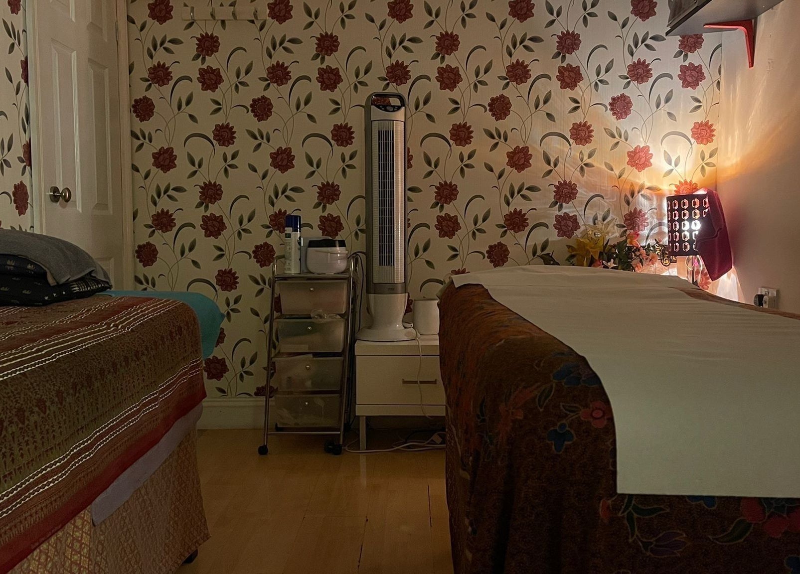 Cozy therapy room at Dee Therapy & Salon, Harrow, England, GB, with floral wallpaper and ambient lighting.