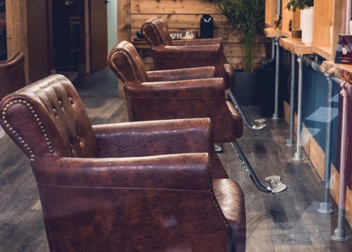 Elegant vintage salon chairs inside Urban Wave, Northam, England, GB, with rustic wooden decor.