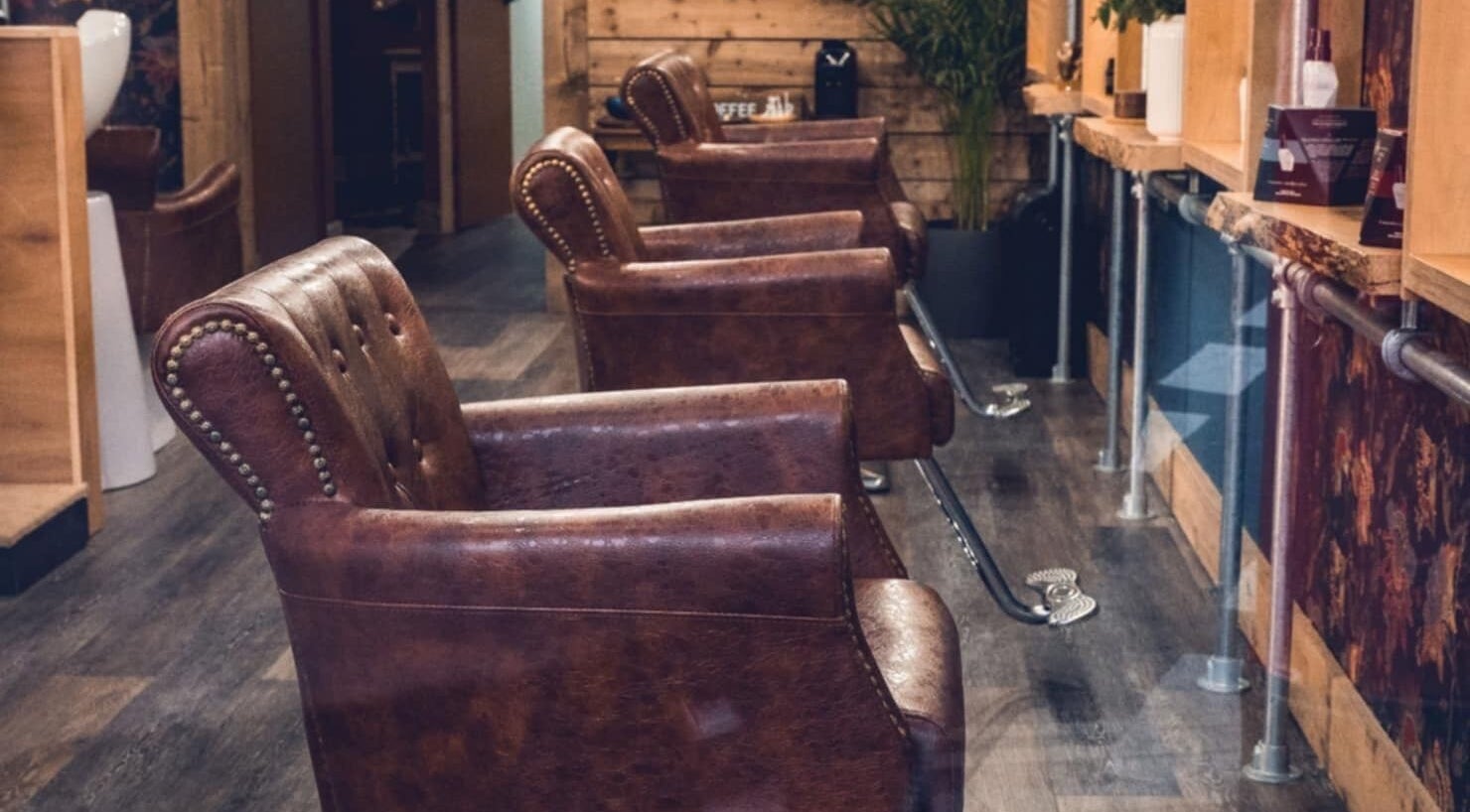 Elegant vintage salon chairs inside Urban Wave, Northam, England, GB, with rustic wooden decor.