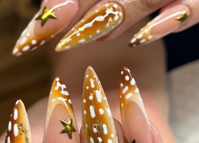 Starry gel nails at Brown Sugar Nail Spa SUITE in Philadelphia, Pennsylvania, US featuring gold stars and patterns.