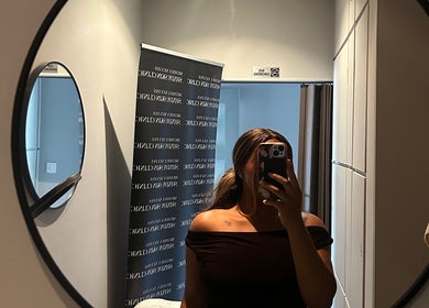 A person takes a mirror selfie in Shxdy Skin Clinic, Manchester, England, GB, featuring modern decor.