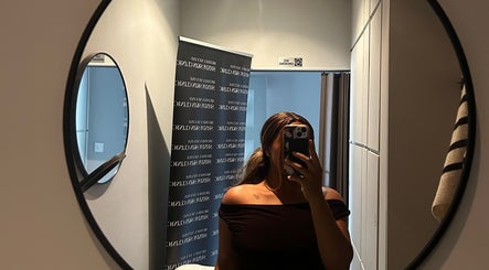 A person takes a mirror selfie in Shxdy Skin Clinic, Manchester, England, GB, featuring modern decor.