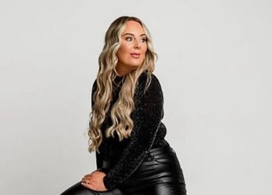 Person seated at Apricot Road Luxury Spray Tanning, Eglinton, Western Australia, showcasing sleek fashion.