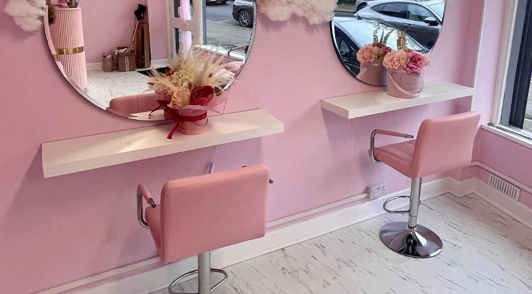 Chic pink beauty salon setup at By Sultan B, Hornchurch, England, GB, featuring stylish chairs and mirrors.